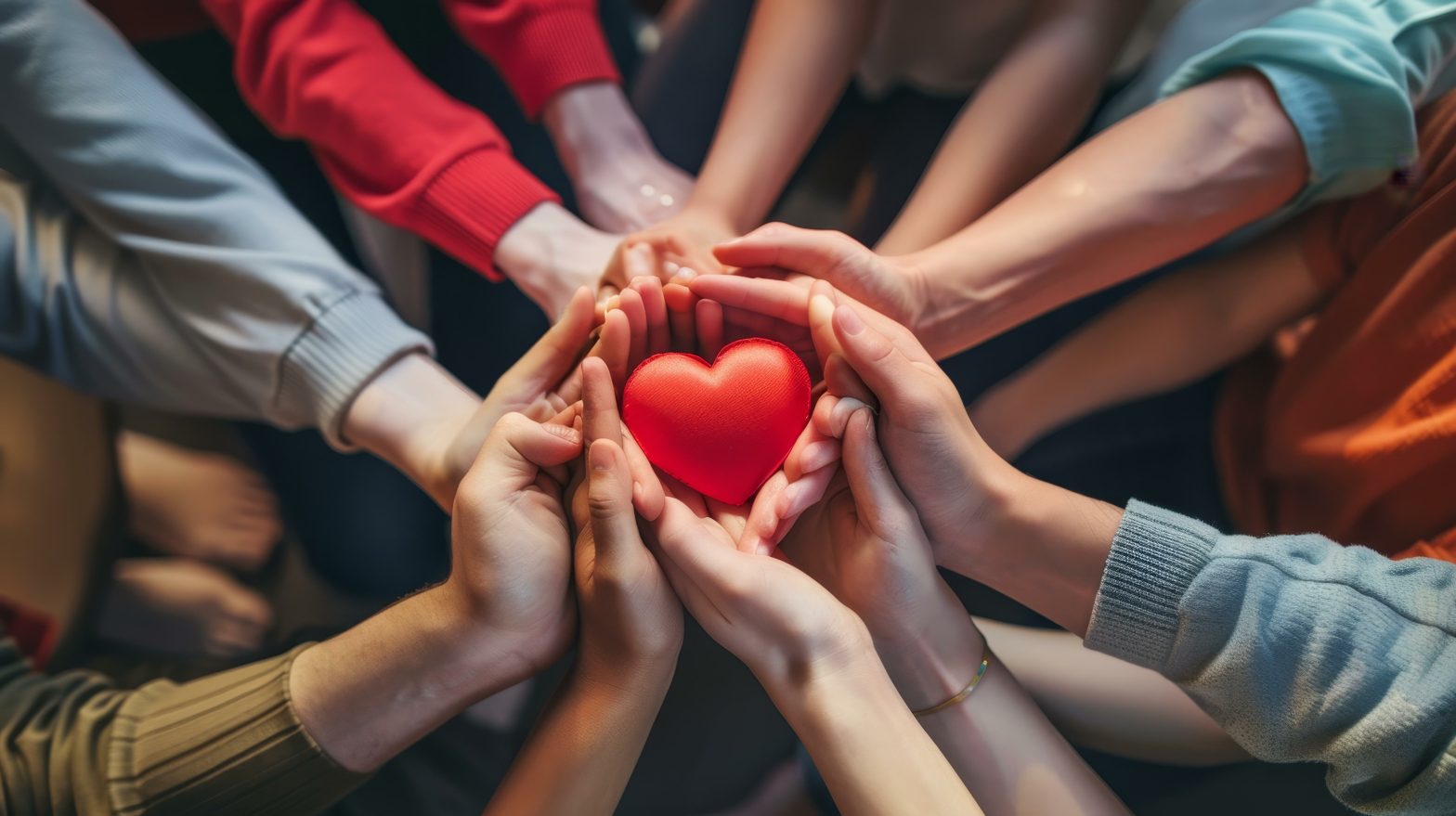 Hands gathered around a heart representing VCCP’s 10/10 Charity Program